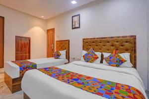 a bedroom with two beds with colorful pillows at FabHotel Beverly Plaza in Mumbai