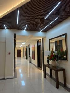 a hallway of an office building with a table and flowers at Uptown Condotel in Bulwa
