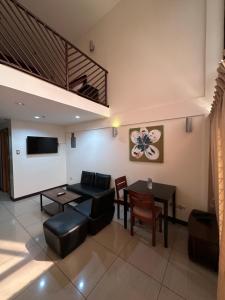 a living room with a couch and a table at Uptown Condotel in Bulwa
