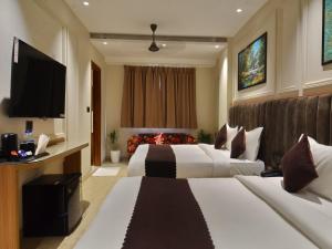 a hotel room with two beds and a flat screen tv at Hotel Maya Cottage' Newly Rebuilt 2026' Near New Delhi Railway Station & Connaught place in New Delhi