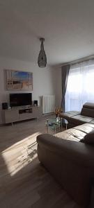 a living room with a couch and a tv at Juliusruh Strandparadies 9 in Juliusruh