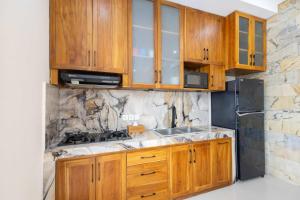 a kitchen with wooden cabinets and a sink at Villa Surga in Denpasar