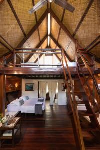 a loft bedroom with a bed and a staircase at Harana Surf Resort in General Luna