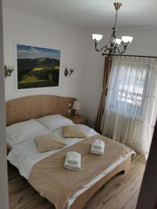 a bedroom with a large bed with two towels on it at Drag de Bucovina in Gura Humorului