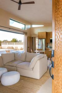 a living room with a white couch and a kitchen at Sand Tulum Retreat w Pool Spa in Yucca Valley