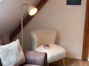 a chair sitting next to a lamp in a room at Fiskerhytte - Meine Fischerhütte in Börgerende-Rethwisch