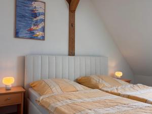 two beds in a bedroom with two lamps and a painting at Fiskerhytte - Meine Fischerhütte in Börgerende-Rethwisch