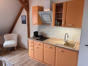 a kitchen with orange cabinets and a sink at Fiskerhytte - Meine Fischerhütte in Börgerende-Rethwisch +43 photos