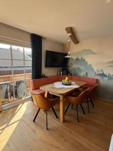a dining room with a table and chairs and a television at Wohnung Kirchstein Highlight Fliegenfischen auf der Isar in Lenggries