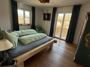 a living room with a couch and two windows at Wohnung Kirchstein Highlight Fliegenfischen auf der Isar in Lenggries