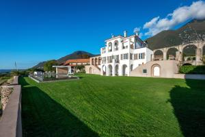 a large white house with a green lawn at Le Selve Lake View Villas in Toscolano Maderno