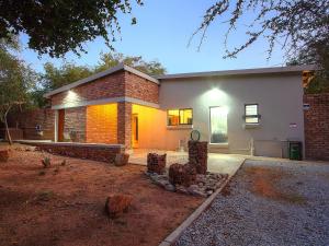 a home with a brick wall and a brick at Spoorzicht in Marloth Park