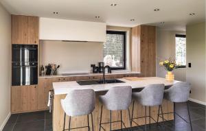 a kitchen with a kitchen island with gray stools at 5 Bedroom Beautiful Home In Oudenaarde in Oudenaarde