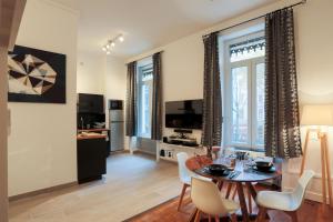 a living room with a table and chairs and a television at Suite Gambetta Cosy et Design in Lyon