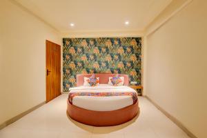 a bedroom with a large bed with a floral wallpaper at FabHotel Relax Inn Executive in Pune