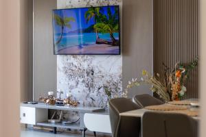 a living room with a tv on a wall at Tropical Escape Flic en Flac in Flic-en-Flac