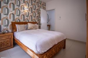 a bedroom with a large bed with a wooden frame at Tropical Escape Flic en Flac in Flic-en-Flac +8 photos