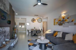 a living room with a couch and a table at Tropical Escape Flic en Flac in Flic-en-Flac