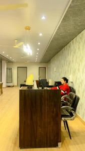 a woman sitting at a desk in an office at Dia Inn in Bori +3 photos