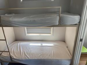 two bunk beds in a small room with a window at Clarence Head Caravan Park in Iluka