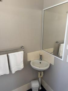 a bathroom with a sink and a mirror and a toilet at Clarence Head Caravan Park in Iluka +63 photos
