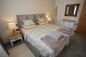 a bedroom with a large bed with pillows on it at Elegant Villa Punta Sol with hot tube, walk to sea and center in Jezera