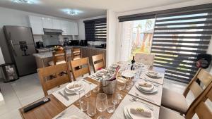 a dining table with plates and glasses on it in a kitchen at BellitasHouse Dream Acapulco Lujo y Confort in Acapulco