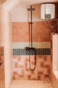 a shower in a bathroom with brown and white tiles at Meli Beach in Galle