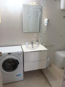 a bathroom with a washing machine and a sink at Cefalù Station House in Cefalù +7 photos