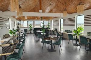a dining room with tables and chairs and windows at Soleya in Antananarivo