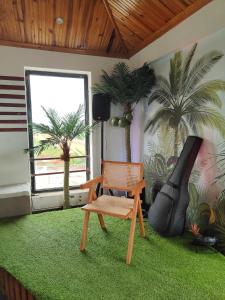 a room with a chair and a hammock and palm trees at Soleya in Antananarivo
