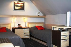 a bedroom with two beds and a desk with two lamps at Garni Hotel Leopold I in Novi Sad