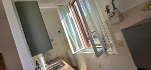 a small bathroom with a sink and a window at The SISTERS in Castel Maggiore