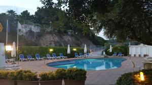 a swimming pool with lounge chairs and a mountain at Gran Sol Hotel in San Pol de Mar