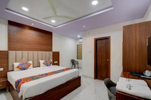 a bedroom with a bed and a desk in a room at FabHotel Palm Tree in Hyderabad