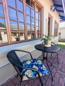 a patio table and chair with a plant on it at Meya B in Harrismith