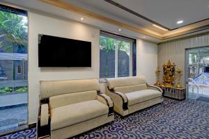 a living room with two chairs and a flat screen tv at FabHotel Palm Tree in Hyderabad