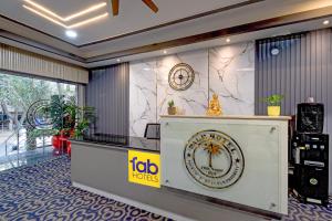 a hotel lobby with a clock on a wall at FabHotel Palm Tree in Hyderabad