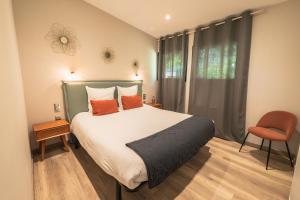 a bedroom with a bed with orange pillows and a window at Domaine le Vaxergues in Saint-Affrique