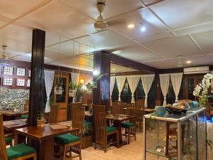 a restaurant with wooden tables and green chairs at Raintree Lodge in Port Moresby