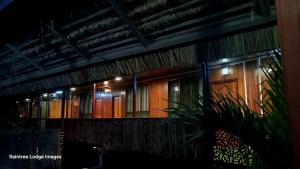 a building with a row of wooden doors at night at Raintree Lodge in Port Moresby