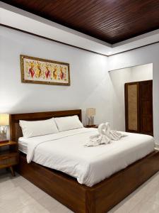 a bedroom with a large bed with white sheets at Molog private villa in Ubud