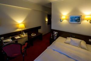 a hotel room with a bed and a desk at Sachsenwald Hotel Reinbek in Reinbek