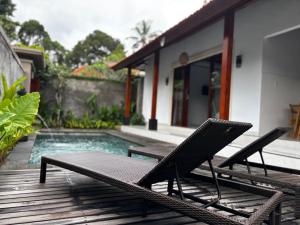 a pair of chairs sitting on a deck next to a pool at Molog private villa in Ubud