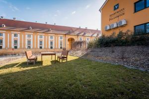 two chairs and a table in front of a building at Apartmany u Polanských Lednice in Lednice