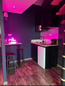 a kitchen with pink lights on the counters at Spa love room in Donges
