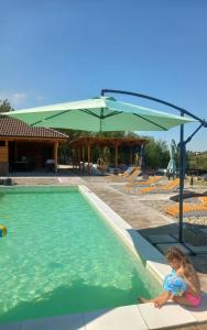 a little girl is sitting in a swimming pool at Etno Vila Ognjilo in Kragujevac