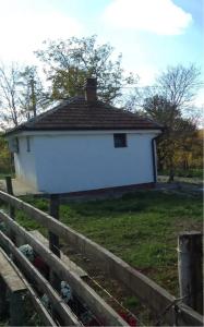 a white house in a field with a fence at Etno Vila Ognjilo in Kragujevac