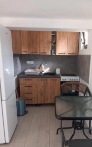 a kitchen with wooden cabinets and a sink and a table at Etno Vila Ognjilo in Kragujevac