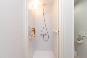 a shower in a white bathroom with a toilet at Evergreen hotel yotsuya in Tokyo